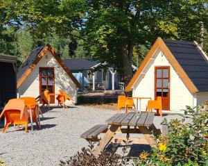 una mesa de picnic y sillas frente a una cabaña en Vakantiepark 't Urkerbos - Kabouterhuisje, en Urk
