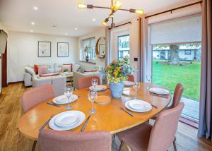 a dining room with a wooden table and chairs at Rwst Holiday Lodges in Llanrwst