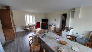 a kitchen and living room with a table and chairs at Maison de village in Corbonod