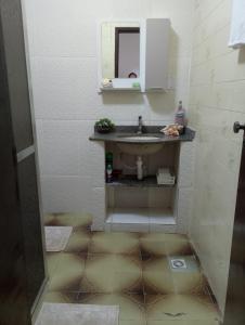 een badkamer met een wastafel en een spiegel bij Apartamento Arara Azul in Cabo Frio