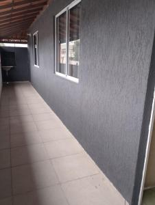 een lege gang met twee ramen en een tegelvloer bij Apartamento Arara Azul in Cabo Frio