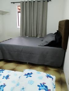 een slaapkamer met een bed en een raam bij Apartamento Arara Azul in Cabo Frio