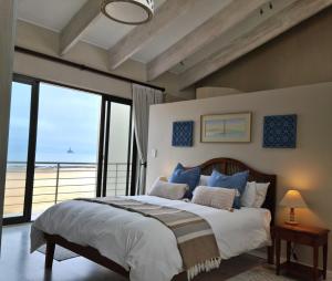 a bedroom with a bed with a view of the ocean at Klippies - Seafront in Langstrand