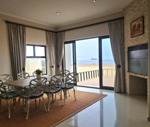a dining room with a table and chairs and a television at Klippies - Seafront in Langstrand