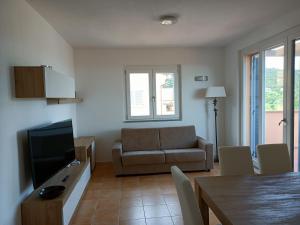 a living room with a couch and a television at Luxury Penthouse 2 camere in Castiglione della Pescaia