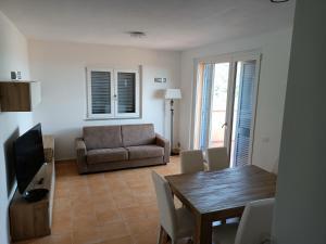 a living room with a dining table and a couch at Luxury Penthouse 2 camere in Castiglione della Pescaia