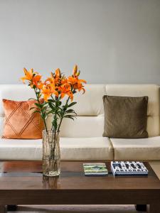 a vase of orange flowers sitting on a coffee table at Hotel Vale Verde in Furnas