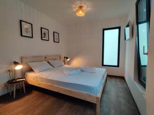 a bedroom with a bed with blue sheets and a window at Daro tiny house in Vama Veche