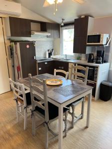 a kitchen with a table and chairs in a kitchen at MOBIL HOME 200m de la mer in Hyères