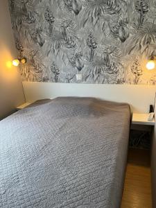 a bedroom with a bed and a wall with a wallpaper at MOBIL HOME 200m de la mer in Hyères