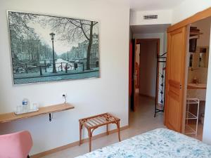 ein Schlafzimmer mit einem Bett und einem Gemälde an der Wand in der Unterkunft Chambres d'hôtes Le Pygargue in Sarlat-la-Canéda