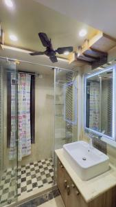 a bathroom with a sink and a ceiling fan at Royal Palace 1 BHK - Kitchen, Balcony, lift, Gym, in New Delhi