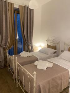 two beds in a room with a window at Il Campanile in Fondi