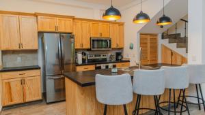 a kitchen with wooden cabinets and a stainless steel refrigerator at Casa Azul in Cruz de Huanacaxtle