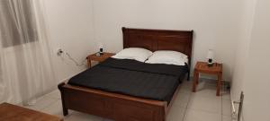 a bedroom with a bed with two night stands and two lamps at T3 Parenthèse des Plaines in La Plaine des Palmistes