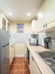 NeepsendにあるModern Stylish 1 Bedroom Homeの白いキャビネットとステンレス製の冷蔵庫を備えたキッチン +12枚の写真
