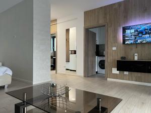 a living room with a glass table and a tv at Garsoniera Zona Centrala in Craiova