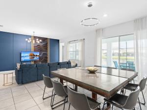 una sala de estar con una mesa y un sofá en SUPER SPACE - 12BD 12BA - MANY ENSUITEs SLEEPs 38, en Kissimmee