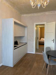 a room with a kitchen with a table and a chandelier at Apotheker Apartments 1901 in Karlovy Vary +10 photos