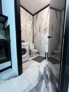 a bathroom with a toilet and a washing machine at Garsoniera Zona Stadion in Craiova +14 photos