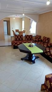 a living room with a table and a couch at Appartement meublé en centre ville in Souani