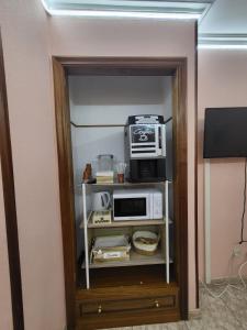 a microwave on a shelf in a room at Paradisiaco Umia in Meis