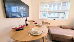 a dining room table with a bottle of wine and glasses at Dunes Apartment by Seaside Llandudno in Llandudno