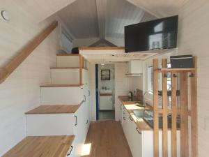 a kitchen with white cabinets and a tv on the ceiling at Mazurski Domek Papy Smerfa plaża pomost jezioro prywatny staw gospodarstwo pasieka in Leśniewo