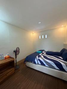 a bedroom with a bed and a fan at Zahra Homestay in Senaru