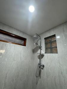 a shower in the corner of a bathroom at Zahra Homestay in Senaru