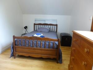 a bedroom with a wooden bed and a dresser at Ma belle Normande entre terre et mer - My beautiful Normandy, between land and sea in Saint-Léonard