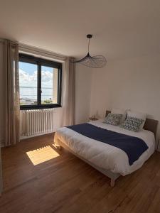 a bedroom with a large bed and a large window at maison vue mer avec terrasse in Brest +7 photos