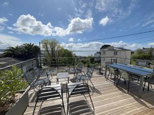 a deck with chairs and a table and a table and chairs at maison vue mer avec terrasse in Brest