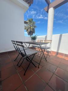 Un patio con una mesa y sillas en un tejado. en Apartamento Taymar Daniel, en Chiclana de la Frontera