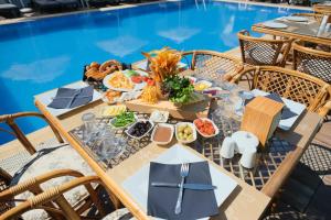 a table with food next to a swimming pool at Çınar Butik Hotel Bodrum in Bodrum City