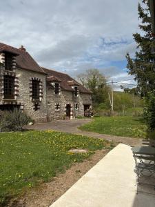 a stone house with a patio and a yard at Studio Fourchaume in Chablis