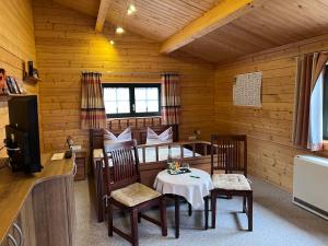 ein Esszimmer mit Tisch und Stühlen in einer Hütte in der Unterkunft Pension Bernhardt in Schwarzenberg/Erzgebirge