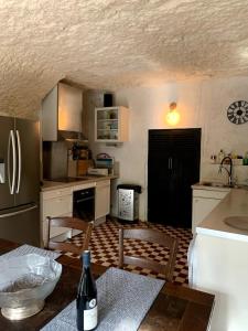 a kitchen with a table with a bottle of wine at Charming troglodyte near Amboise in Pocé-sur-Cisse +20 photos