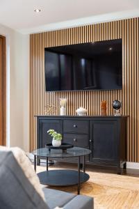 a living room with a tv on a wall at Grovefield Getaway in Belfast