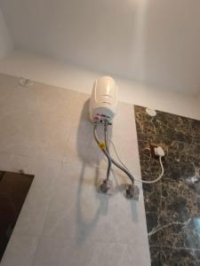 a white blow dryer on the floor in a room at Tranquil Flat Near Ganges in Birbhaddar +8 photos