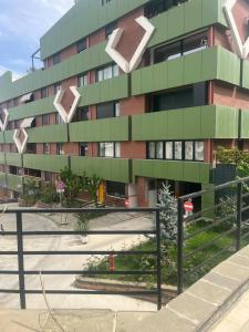 a tall green building with white arrows on it at Kodra e diellit residence 2 in Selitë e Vogël