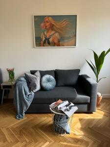 a living room with a couch and a painting on the wall at Apartament Lady Eleven in Gdańsk