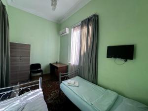 una camera d'albergo con due letti e una televisione di Bridge House Yerevan Armenia a Yerevan