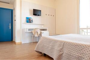 a bedroom with a bed and a tv on the wall at Hotel Oceano in Marina di Pietrasanta