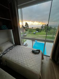 une chambre avec un lit et une vue sur une piscine dans l'établissement Apartamento de frente para lagoa -Ap 101, à Laguna 15 autres photos
