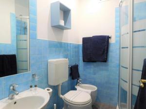 a blue tiled bathroom with a toilet and a sink at Hotel Oceano in Marina di Pietrasanta +91 photos