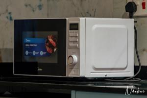 ダル・エス・サラームにあるNdekai Coveのカウンターの上に置かれた電子レンジ +9枚の写真
