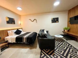 a hotel room with a bed and a chair at Bacaanda #2 in Oaxaca City