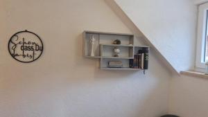 a book shelf on a wall with a clock at Ruheoase Sternig in Bad Bleiberg