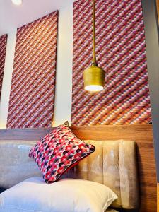 a room with two large windows and a couch with pillows at The Ganesh Kuti in Pātan